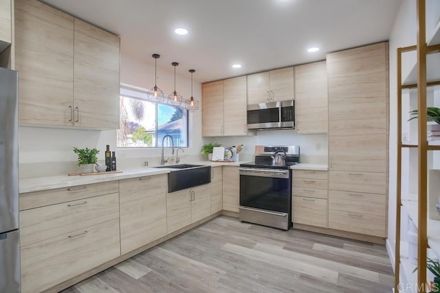 4197 Tiberon Dr, Oceanside, CA 92056 - kitchen with modern cabinets, light brown cabinetry, a sink, appliances with stainless steel finishes, and light countertops
