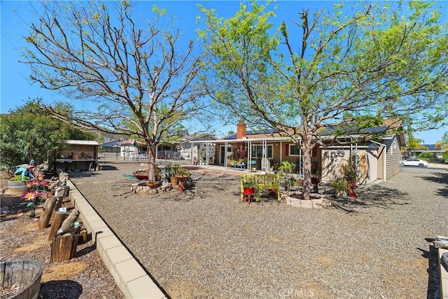 view of front of home with a patio, fence, and a chimney