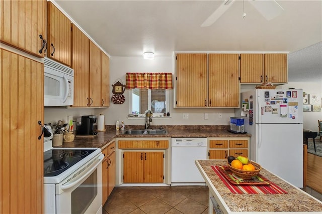 kitchen with dark tile patterned floors, white appliances, ceiling fan, and a sink