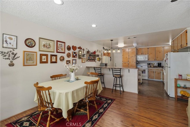 dining space with visible vents, recessed lighting, a textured ceiling, and dark wood-type flooring