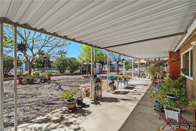 view of patio with an outbuilding, a fenced backyard, and a shed