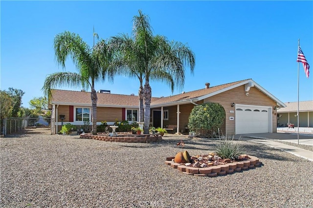 ranch-style house featuring concrete driveway, an attached garage, and fence