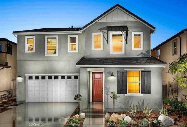 view of front of property with a garage, driveway, and stucco siding