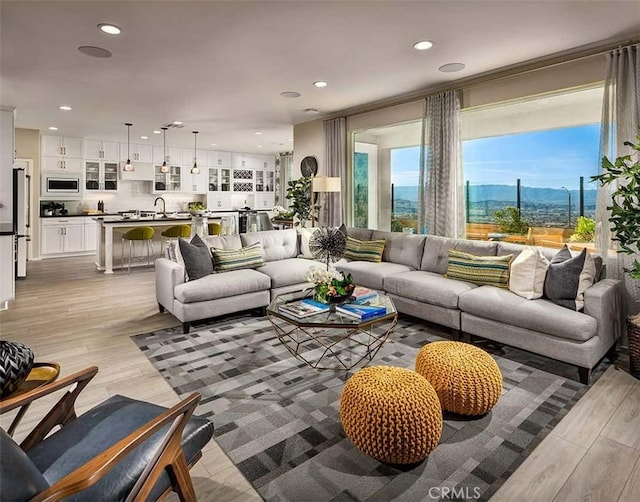 living area featuring light wood-style flooring, recessed lighting, and a mountain view