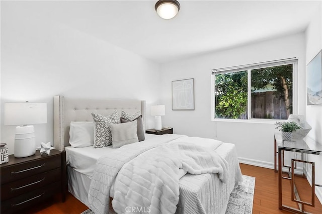 bedroom with baseboards and wood finished floors