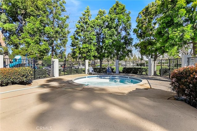 view of swimming pool with fence and playground community