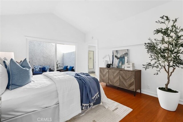 bedroom with vaulted ceiling and wood finished floors