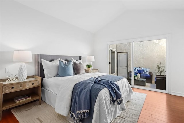 bedroom with access to exterior, lofted ceiling, and hardwood / wood-style floors