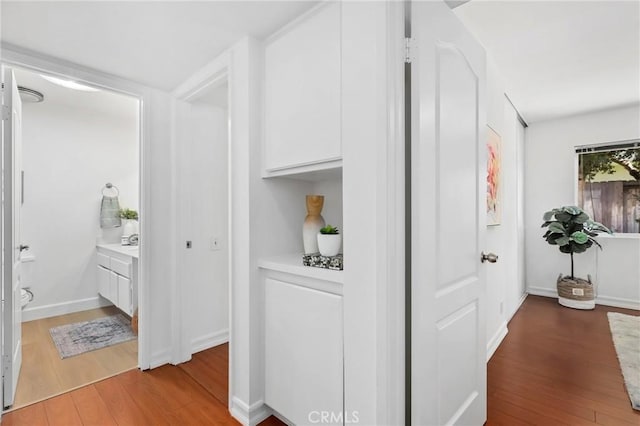 hallway with baseboards and wood finished floors