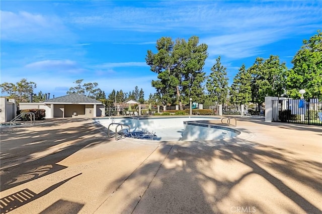 community pool featuring a patio area and fence