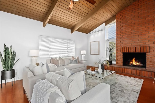 living room with wood finished floors, baseboards, vaulted ceiling with beams, a fireplace, and wooden ceiling