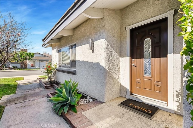 view of exterior entry featuring stucco siding