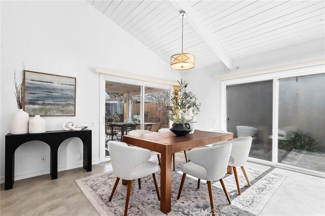 dining space featuring beam ceiling and high vaulted ceiling