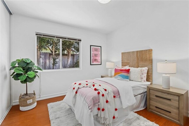 bedroom with baseboards and wood finished floors