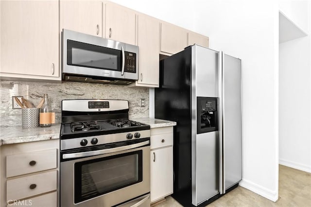 kitchen featuring light stone countertops, baseboards, tasteful backsplash, and appliances with stainless steel finishes