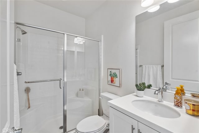 bathroom featuring a stall shower, toilet, and vanity