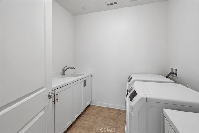 clothes washing area featuring visible vents, washer and clothes dryer, a sink, cabinet space, and baseboards