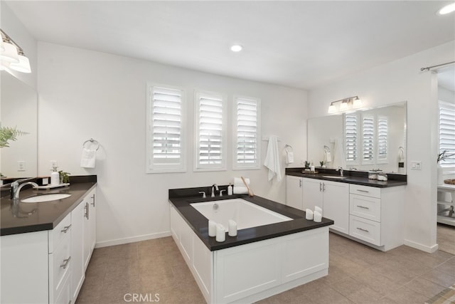 bathroom with two vanities, a wealth of natural light, and a sink