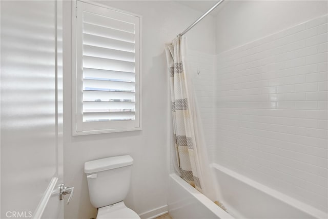 bathroom featuring shower / bath combination with curtain and toilet