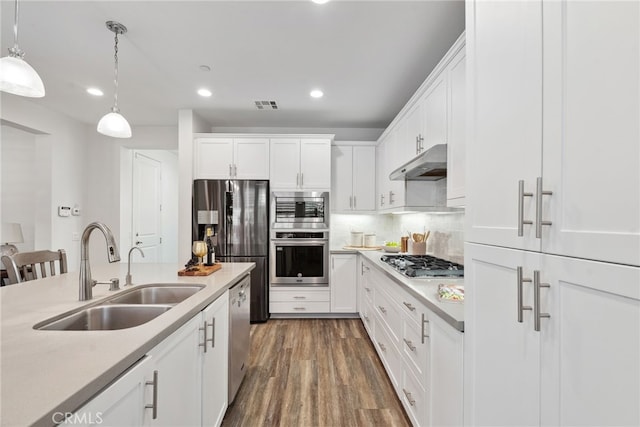 kitchen with visible vents, a sink, stainless steel appliances, light countertops, and under cabinet range hood