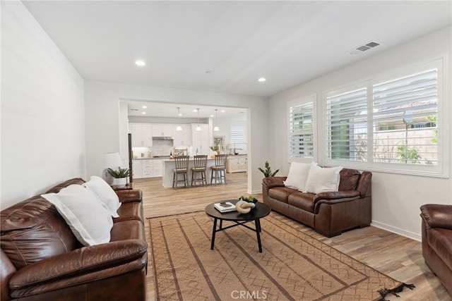 living room featuring recessed lighting, visible vents, baseboards, and light wood-style floors