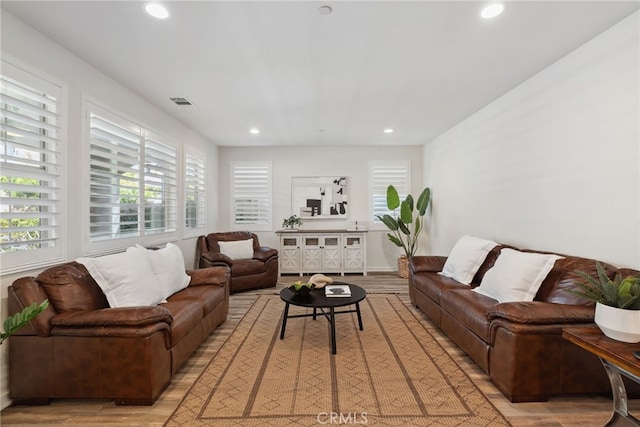 living room featuring visible vents, recessed lighting, and light wood-type flooring