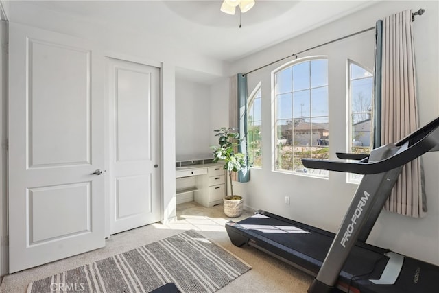 workout room with light colored carpet and ceiling fan