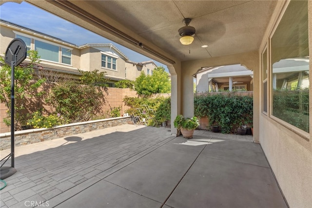 view of patio with ceiling fan and fence