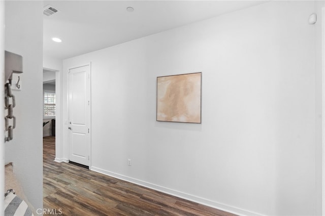 corridor featuring dark wood-style floors, visible vents, recessed lighting, and baseboards