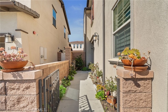 view of side of home with fence and stucco siding