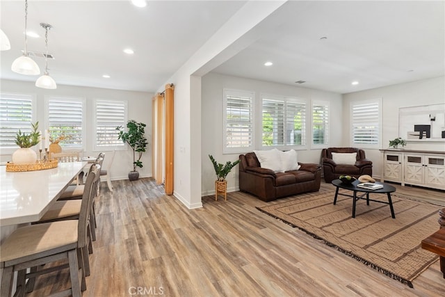 living area featuring recessed lighting, baseboards, and light wood-style floors