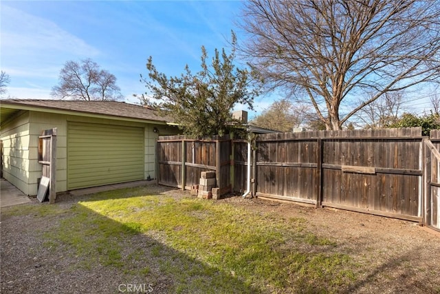 view of yard featuring an outdoor structure, fence, and a garage