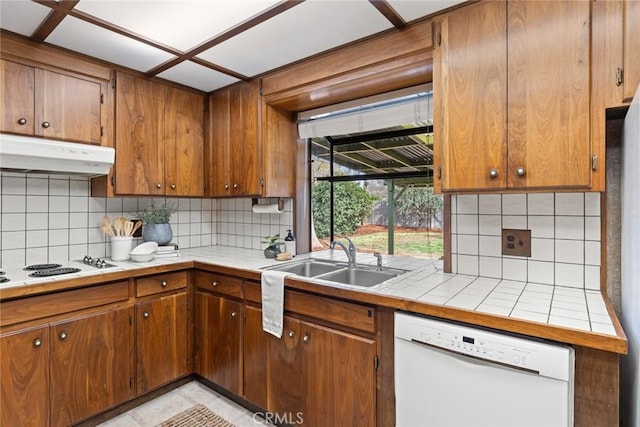 kitchen featuring under cabinet range hood, white appliances, tile countertops, and a sink