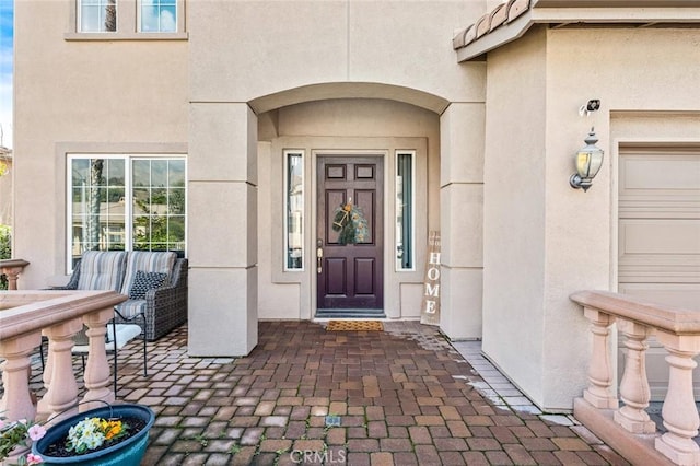 entrance to property featuring stucco siding and a garage