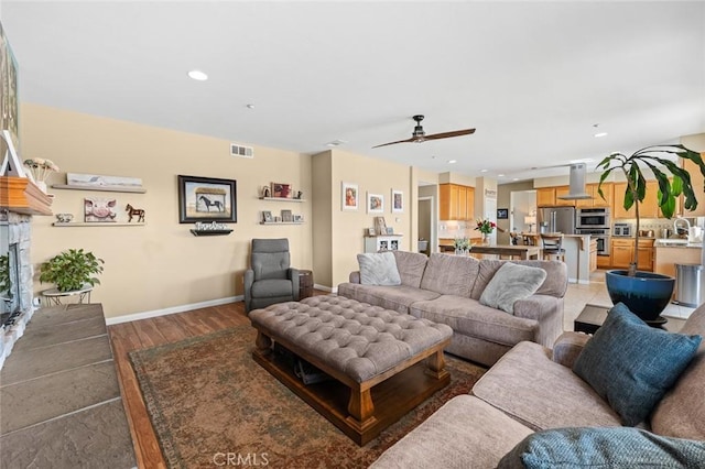 living room with visible vents, recessed lighting, light wood finished floors, baseboards, and ceiling fan