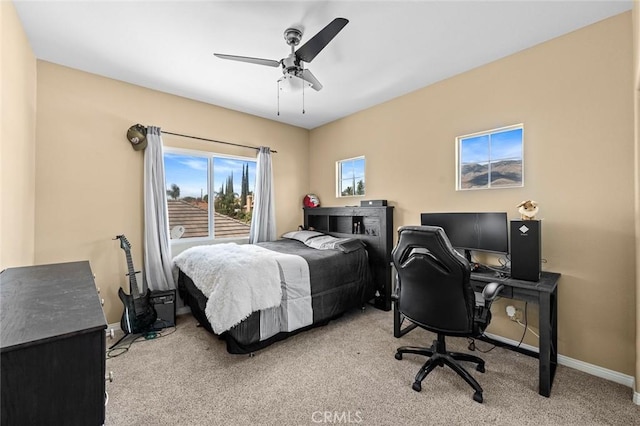 bedroom with a ceiling fan, baseboards, and light carpet