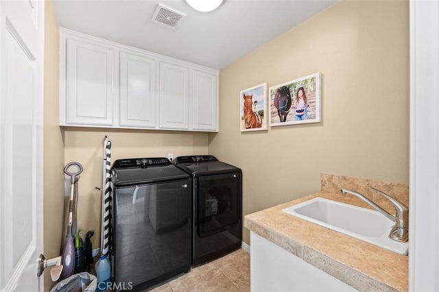 laundry area featuring visible vents, washer and clothes dryer, light tile patterned floors, cabinet space, and a sink