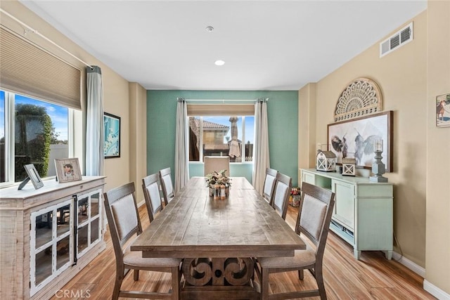 dining area featuring light wood-style floors, visible vents, and a wealth of natural light