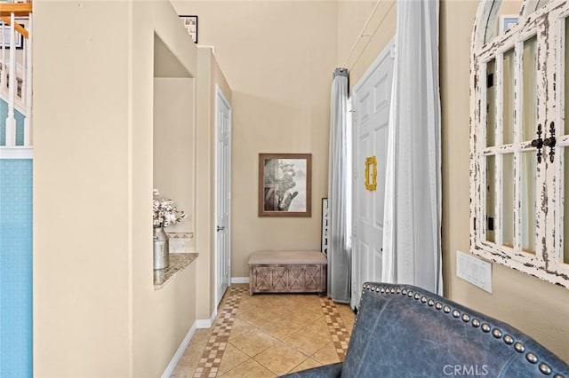 hallway with baseboards and light tile patterned flooring