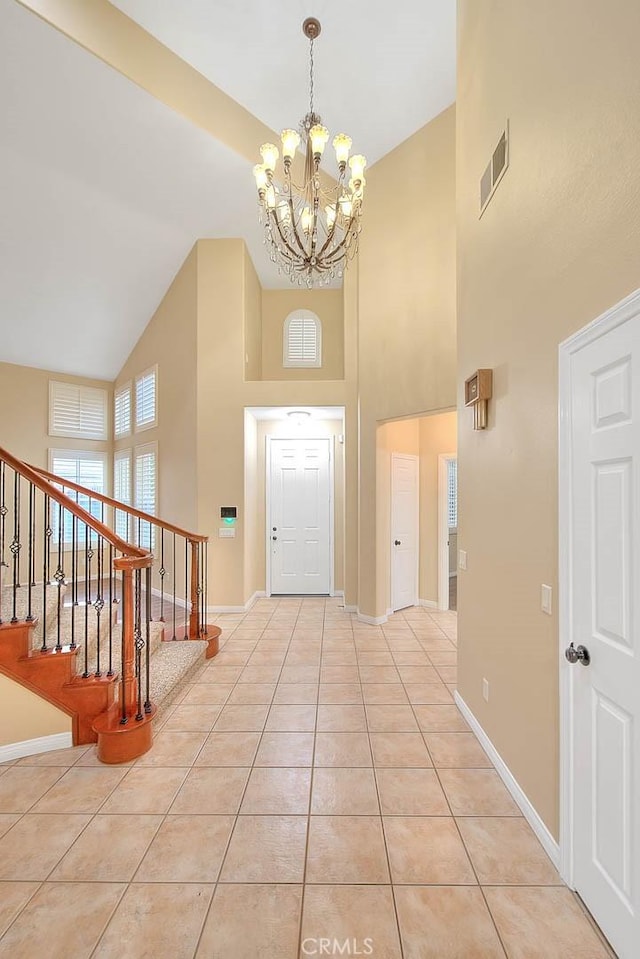 foyer entrance featuring baseboards, visible vents, light tile patterned flooring, stairs, and a chandelier