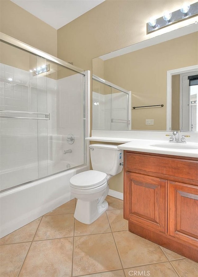 full bathroom featuring combined bath / shower with glass door, toilet, vanity, and tile patterned flooring