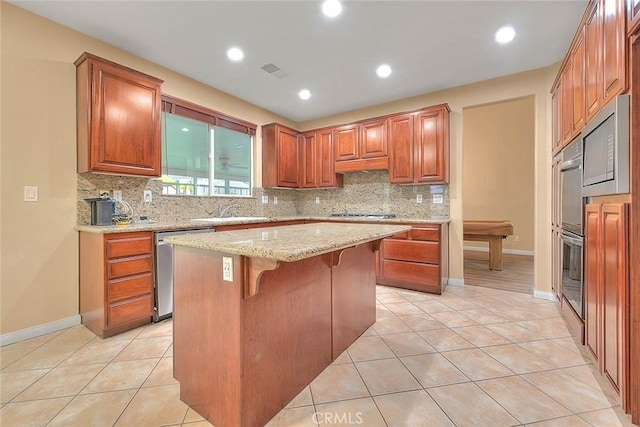 kitchen with visible vents, backsplash, a breakfast bar area, light tile patterned floors, and stainless steel appliances