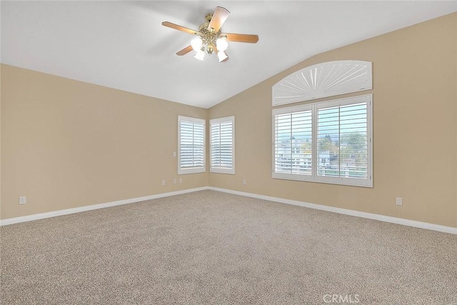 carpeted spare room with baseboards, a ceiling fan, and vaulted ceiling