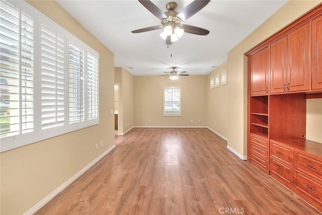 interior space featuring light wood-style flooring, baseboards, and ceiling fan