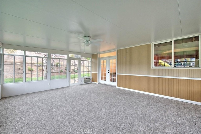 unfurnished sunroom featuring french doors, an AC wall unit, and ceiling fan