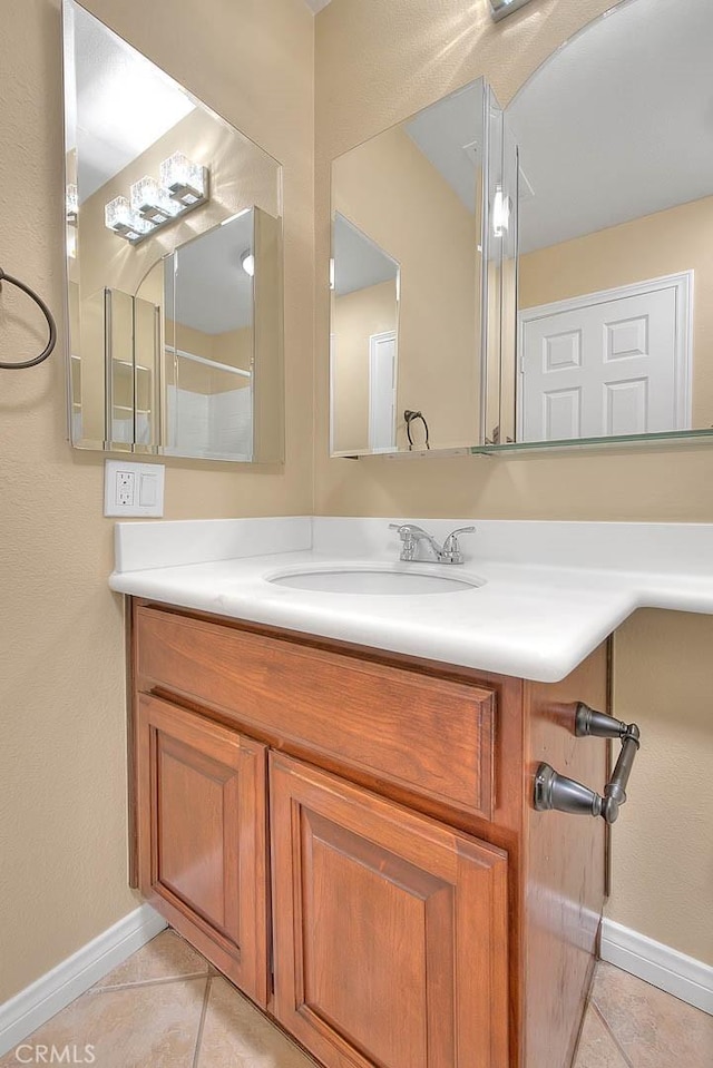 bathroom featuring baseboards, vanity, and tile patterned flooring