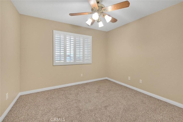 carpeted empty room featuring ceiling fan and baseboards