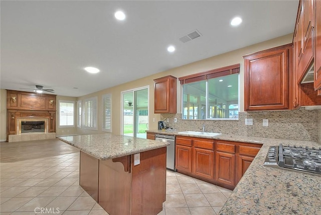 kitchen featuring visible vents, a sink, a kitchen island, stainless steel appliances, and light tile patterned floors