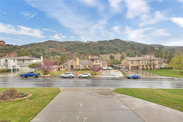 exterior space with a mountain view, a residential view, and driveway