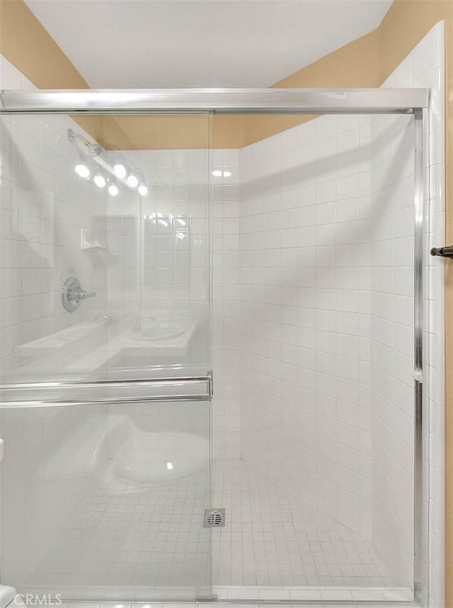 full bathroom featuring a shower stall and vaulted ceiling